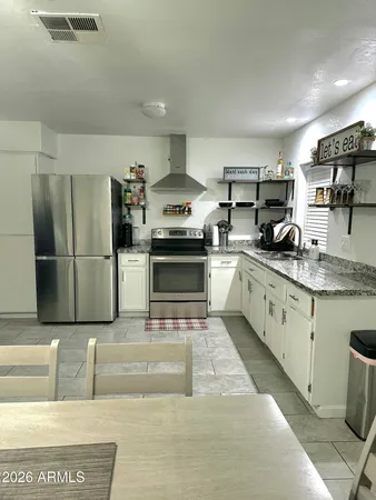 a kitchen with stainless steel appliances granite countertop a refrigerator sink and stove