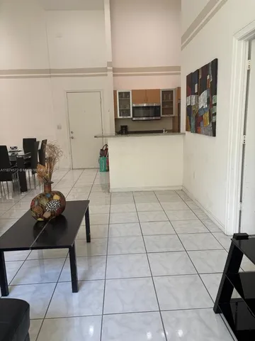 a living room with furniture a flat screen tv and kitchen view