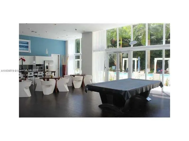 a dining room with furniture and a large window