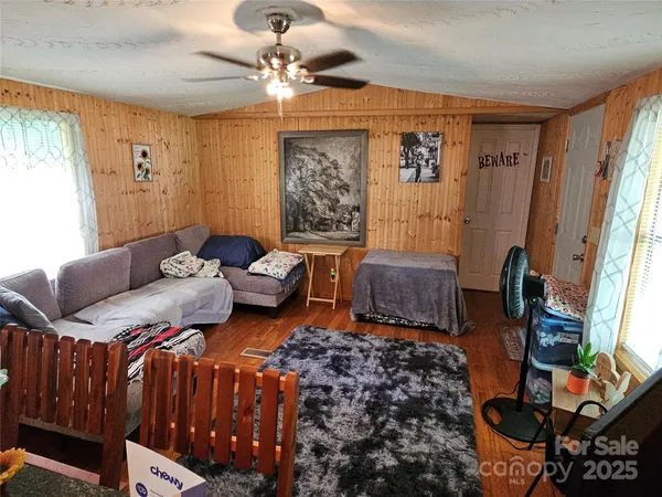 a living room with furniture ceiling fan and a window