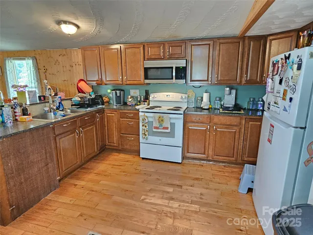 a kitchen with stainless steel appliances granite countertop a stove sink refrigerator and cabinets