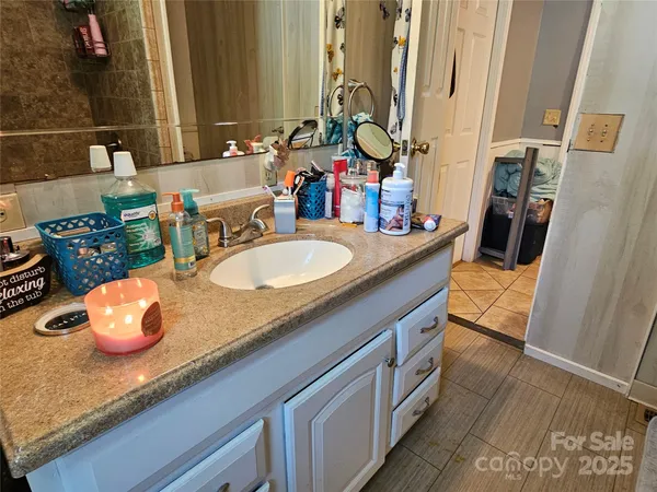 a bathroom with a granite countertop double vanity and a mirror