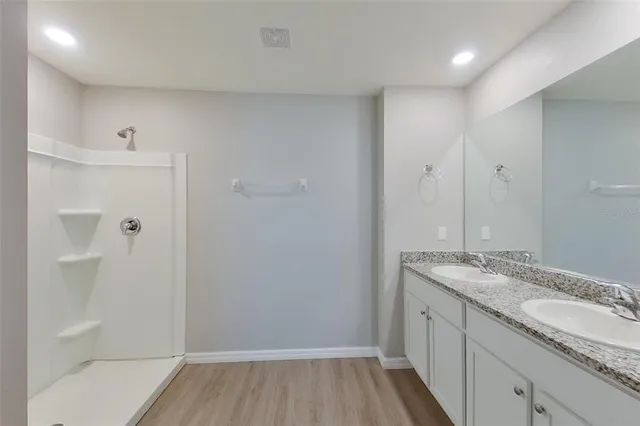 a bathroom with a granite countertop sink and shower