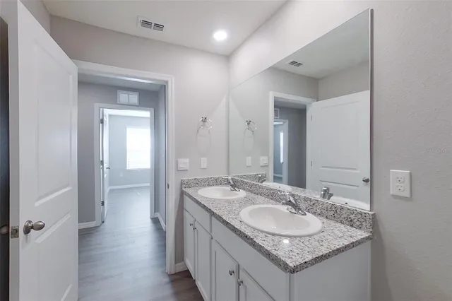 a bathroom with a granite countertop sink and a mirror