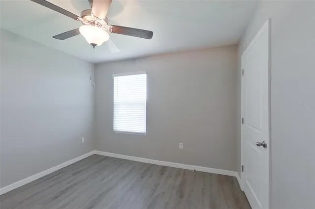 an empty room with a window and a fan