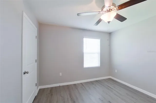 an empty room with a window and a fan