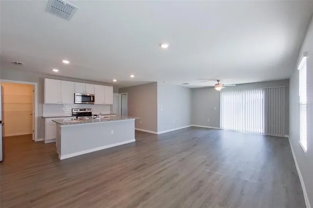 a large space with a large kitchen counter top and stainless steel appliances