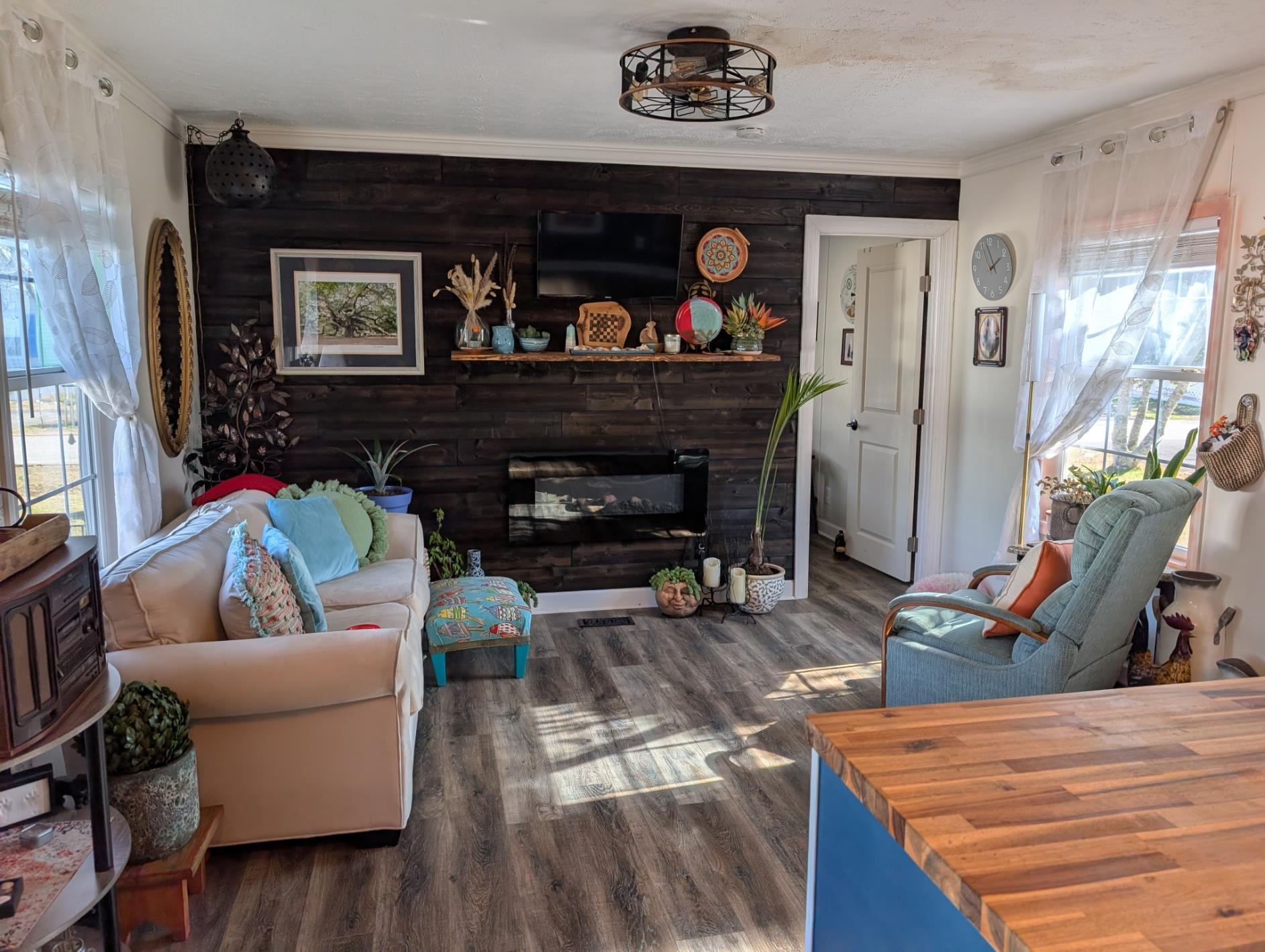 3 Poolside Drive Murrells Inlet, SC 29576 - Photo 13 of 40 Living area featuring plenty of natural light, dark wood finished floors, wood walls, a glass covered fireplace, and ornamental molding