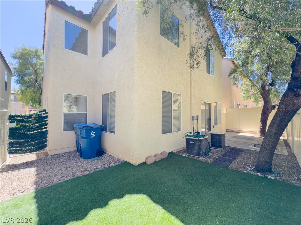 9456 Grandview Spring Avenue Las Vegas, NV 89166 - Photo 41 of 49 A well-maintained side yard features a blend of artificial turf and gravel, complemented by mature shade trees.