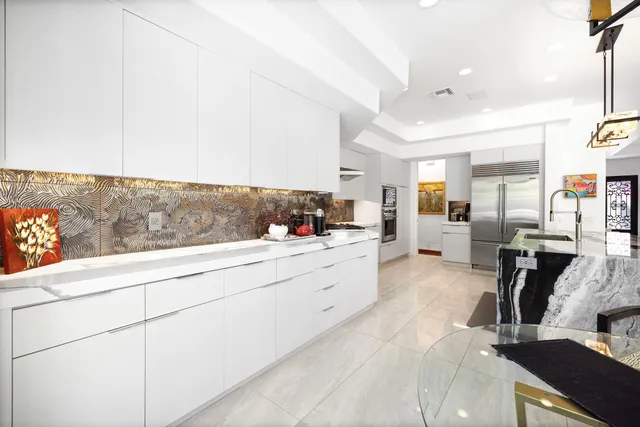 a large white kitchen with cabinets