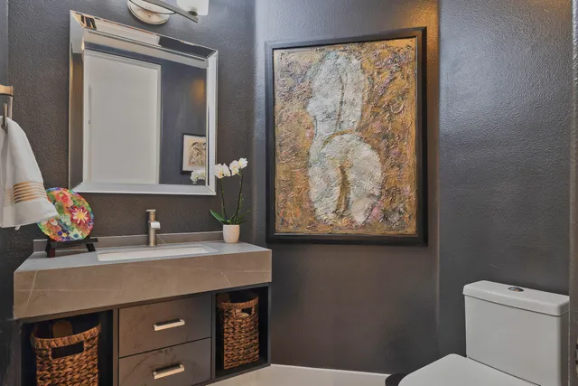 a bathroom with a sink a toilet and mirror