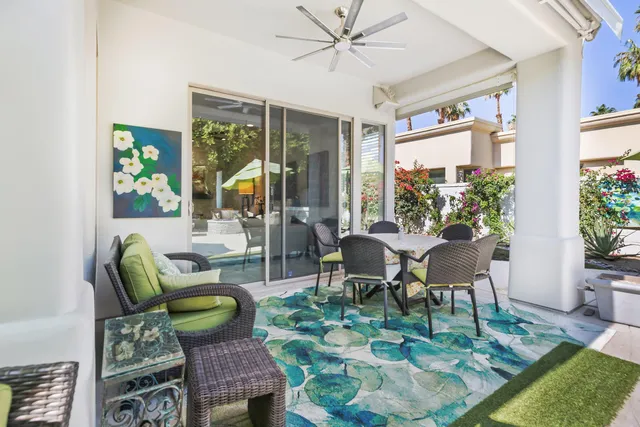 a living room with furniture a dining table and a potted plant