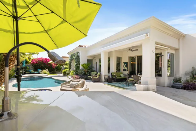 a view of a patio with a table and chairs under an umbrella