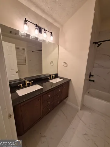 a bathroom with a double vanity sink a mirror and a bathtub