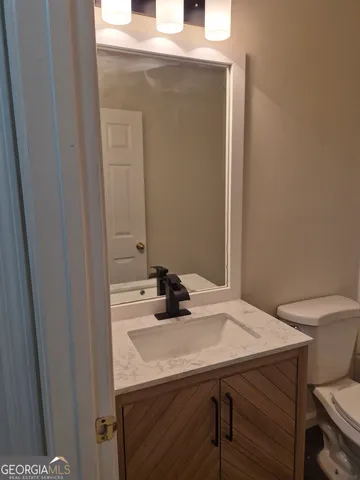 a bathroom with a sink a toilet and mirror