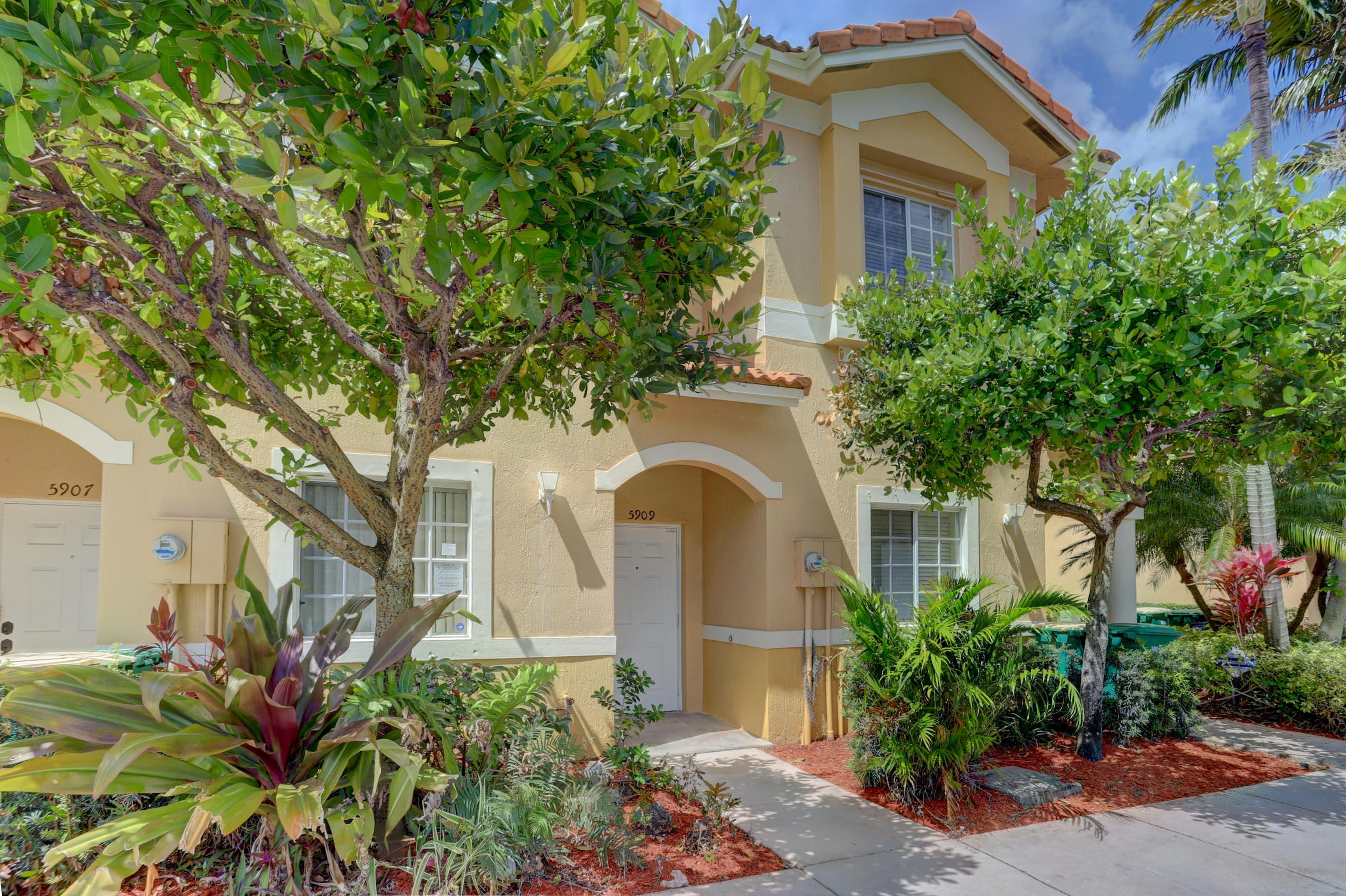 5909 Riverside Avenue Tamarac, FL 33321 - Photo 1 of 32 a front view of a house with a yard