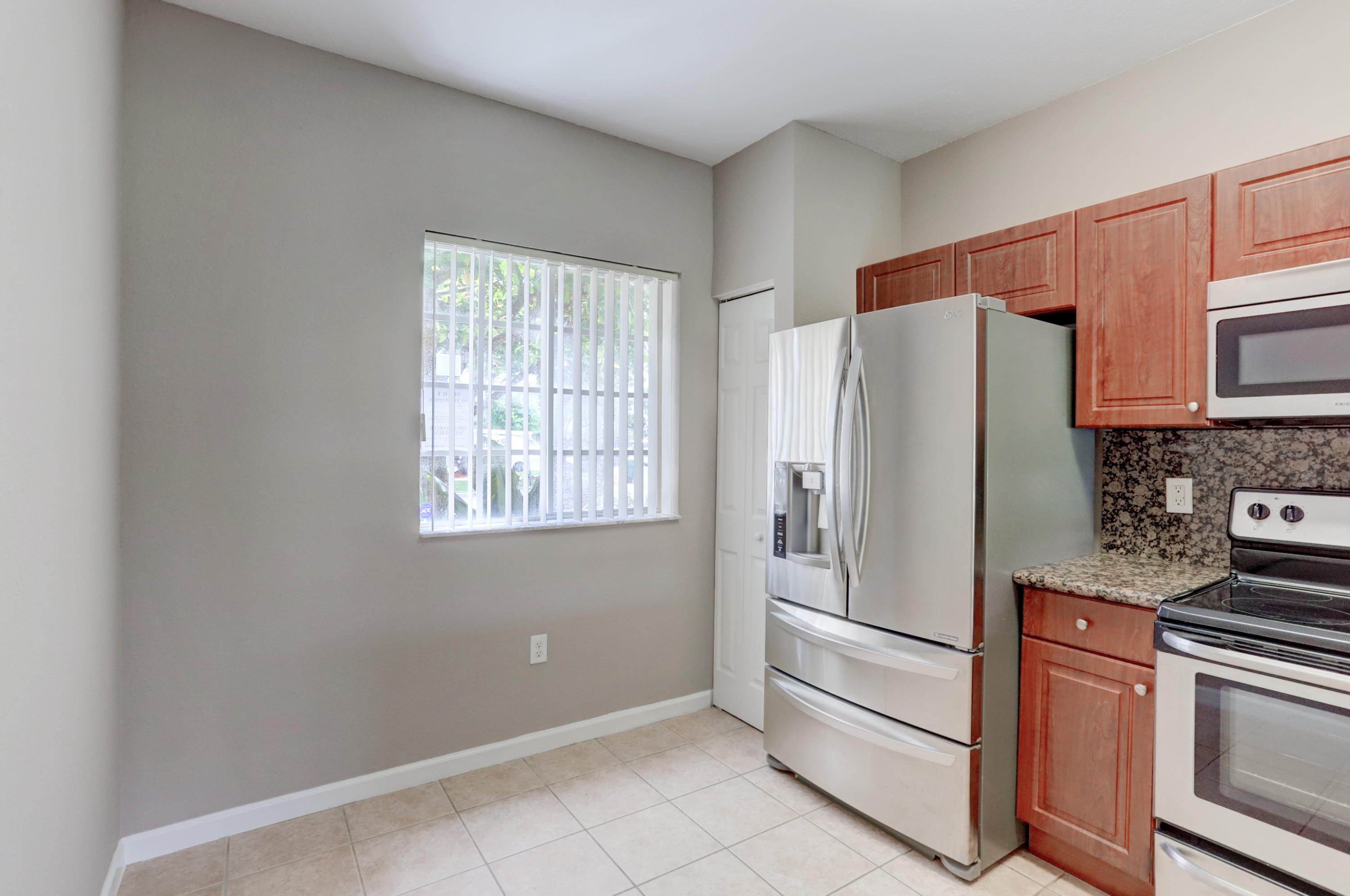 5909 Riverside Avenue Tamarac, FL 33321 - Photo 13 of 32 a kitchen with stainless steel appliances a refrigerator sink and microwave