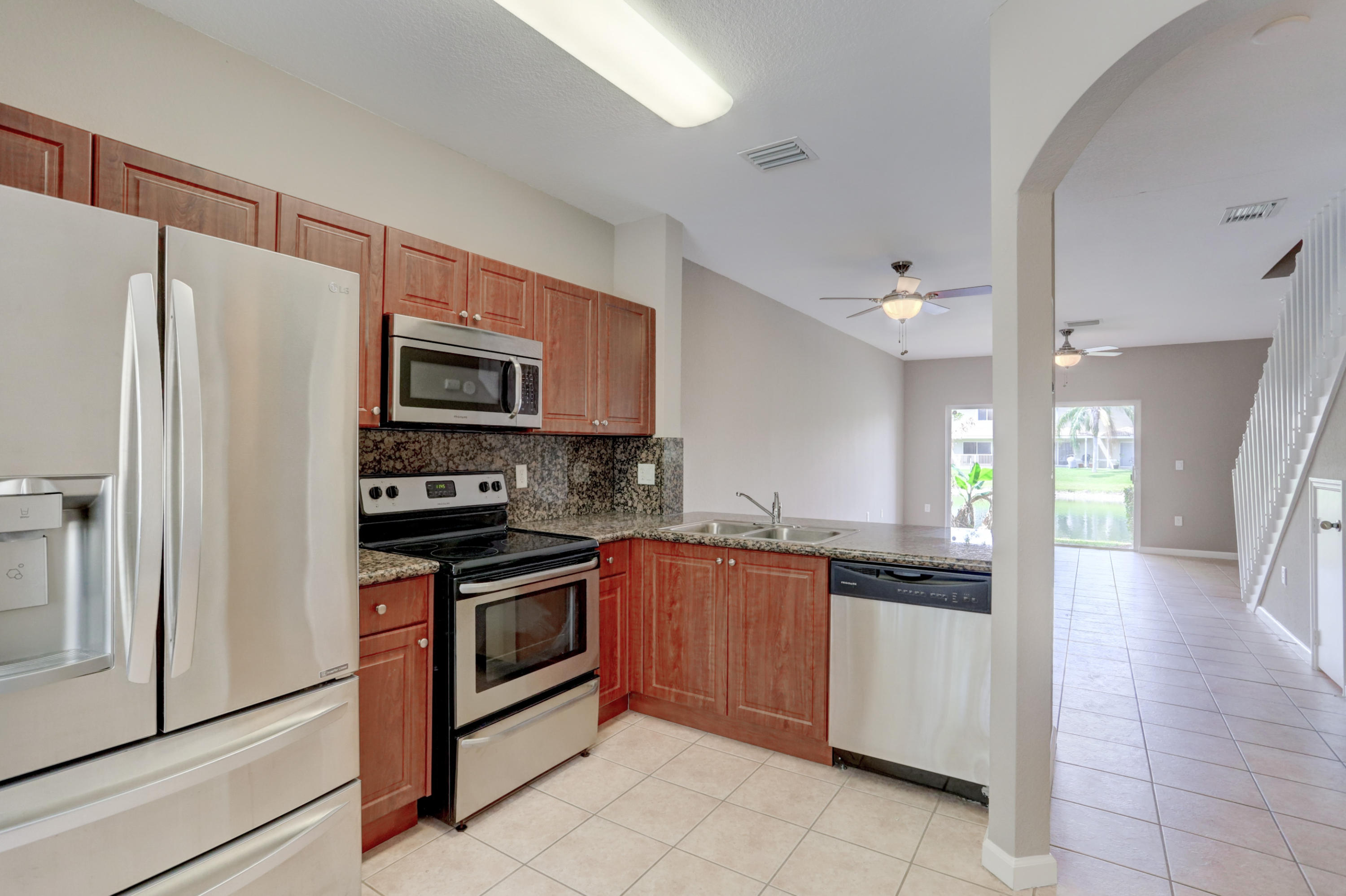 5909 Riverside Avenue Tamarac, FL 33321 - Photo 14 of 32 a kitchen with stainless steel appliances granite countertop a refrigerator and a stove top oven