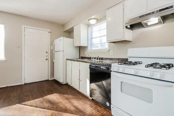 a kitchen with a refrigerator stove and white cabinets