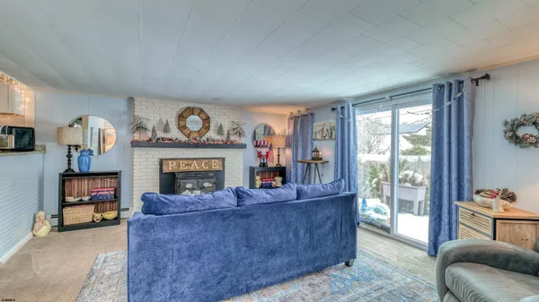 a living room with furniture a fireplace and a large window