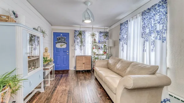 a living room with furniture and a wooden floor