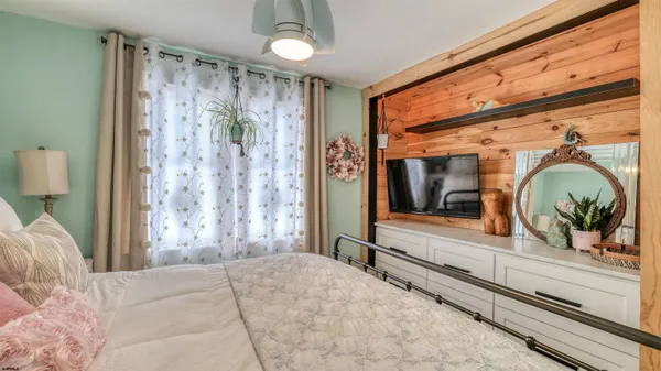 a bedroom with a bed and a large window