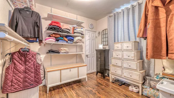 a view of walk in closet with clothes and shoes