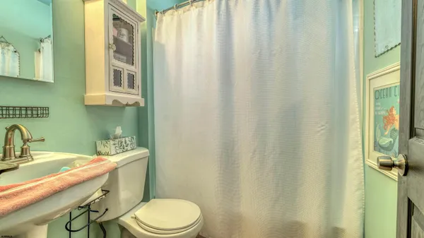 a bathroom with a sink a toilet and shower curtain