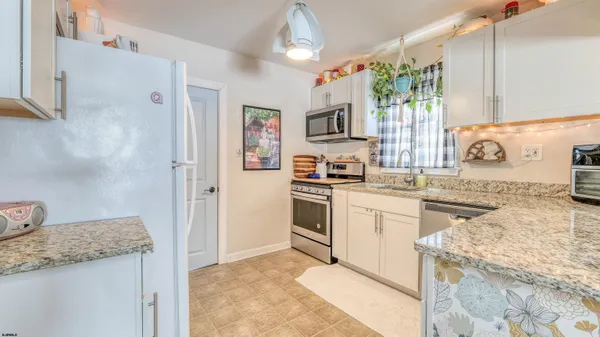 a kitchen with granite countertop a sink stove and refrigerator