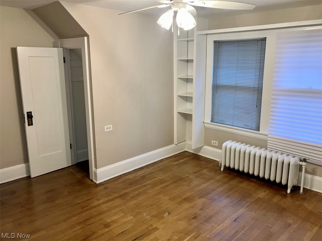 2108 Volney Road Youngstown, OH 44511 - Photo 17 of 27 Empty room with ceiling fan, dark wood-type flooring, and radiator