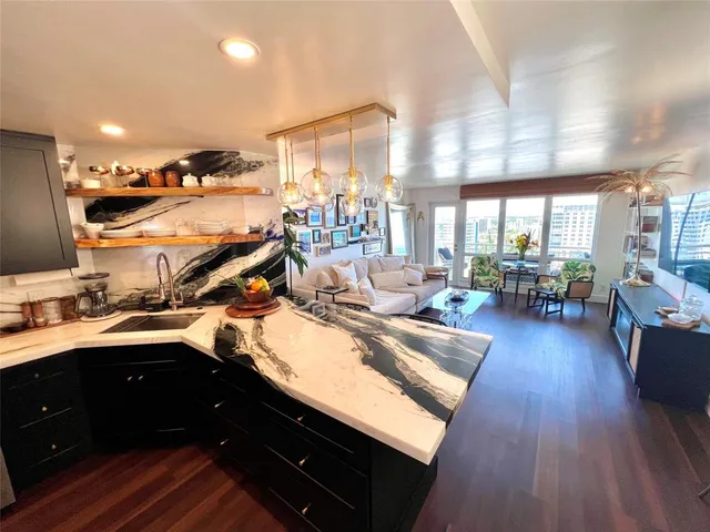 a kitchen with a sink appliances and wooden floor
