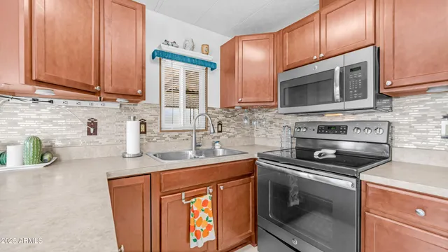a kitchen with stainless steel appliances granite countertop a sink stove and cabinets