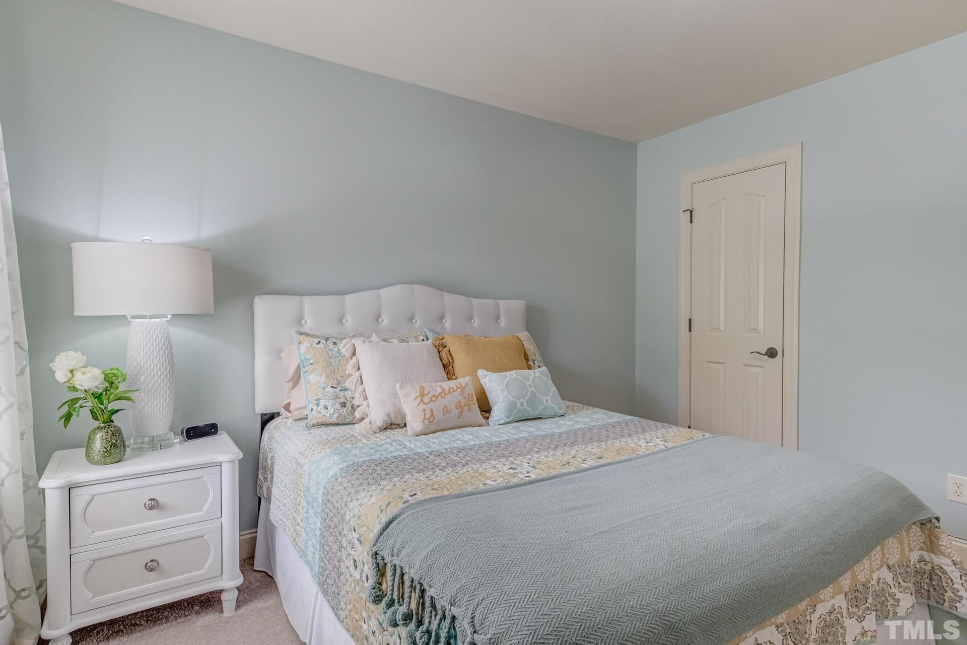 108 Challenge Road Raleigh, NC 27603 - Photo 32 of 60 a bedroom with a bed and a potted plant