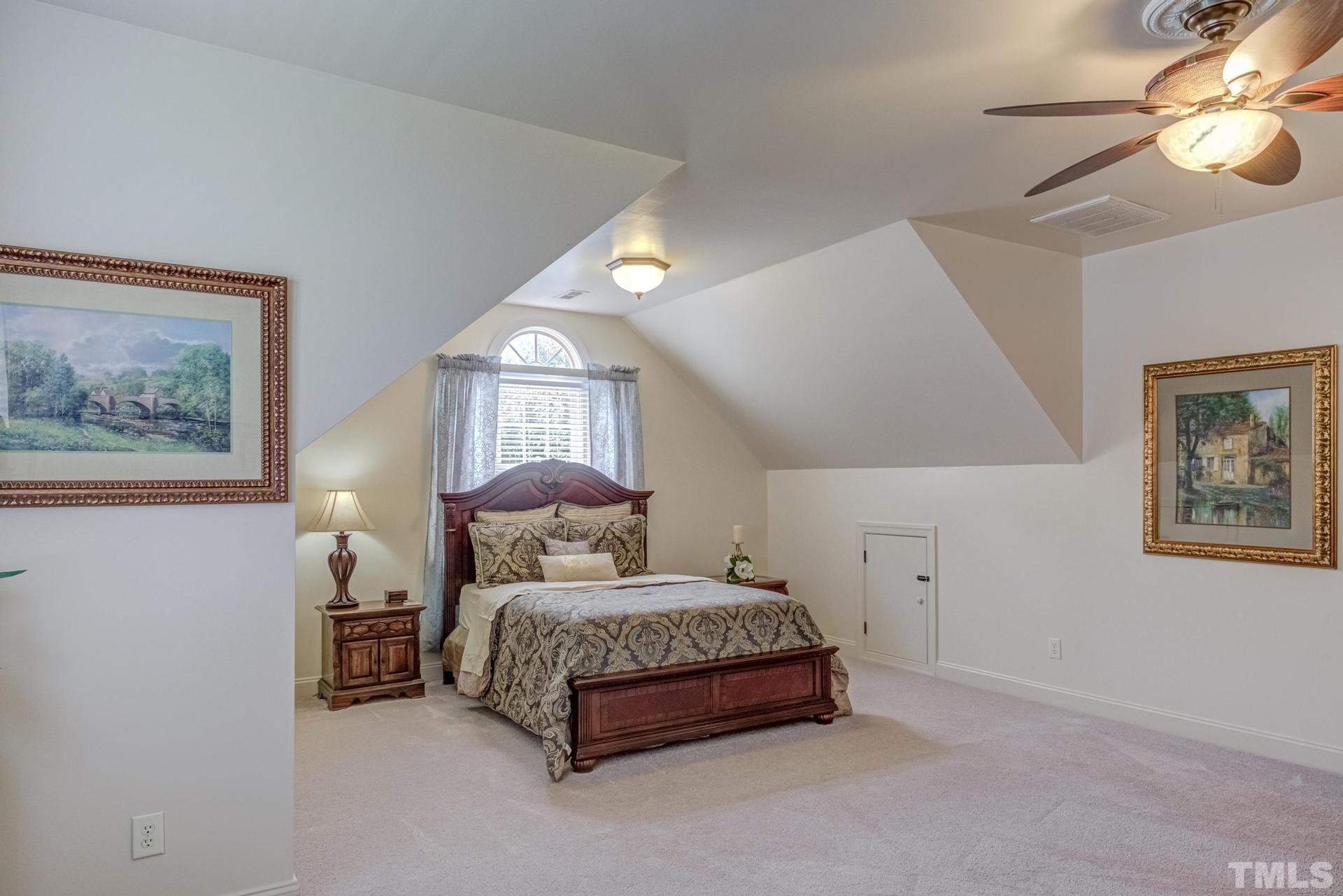 108 Challenge Road Raleigh, NC 27603 - Photo 49 of 60 a bedroom with a bed and a chandelier