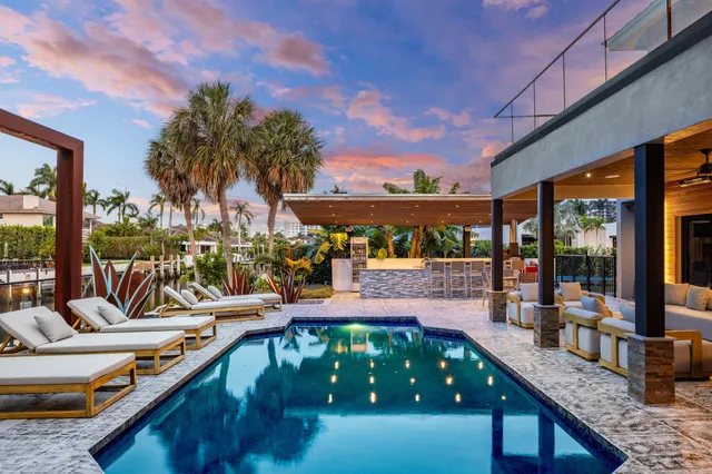 a kitchen with stainless steel appliances kitchen island granite countertop a table and chairs in it