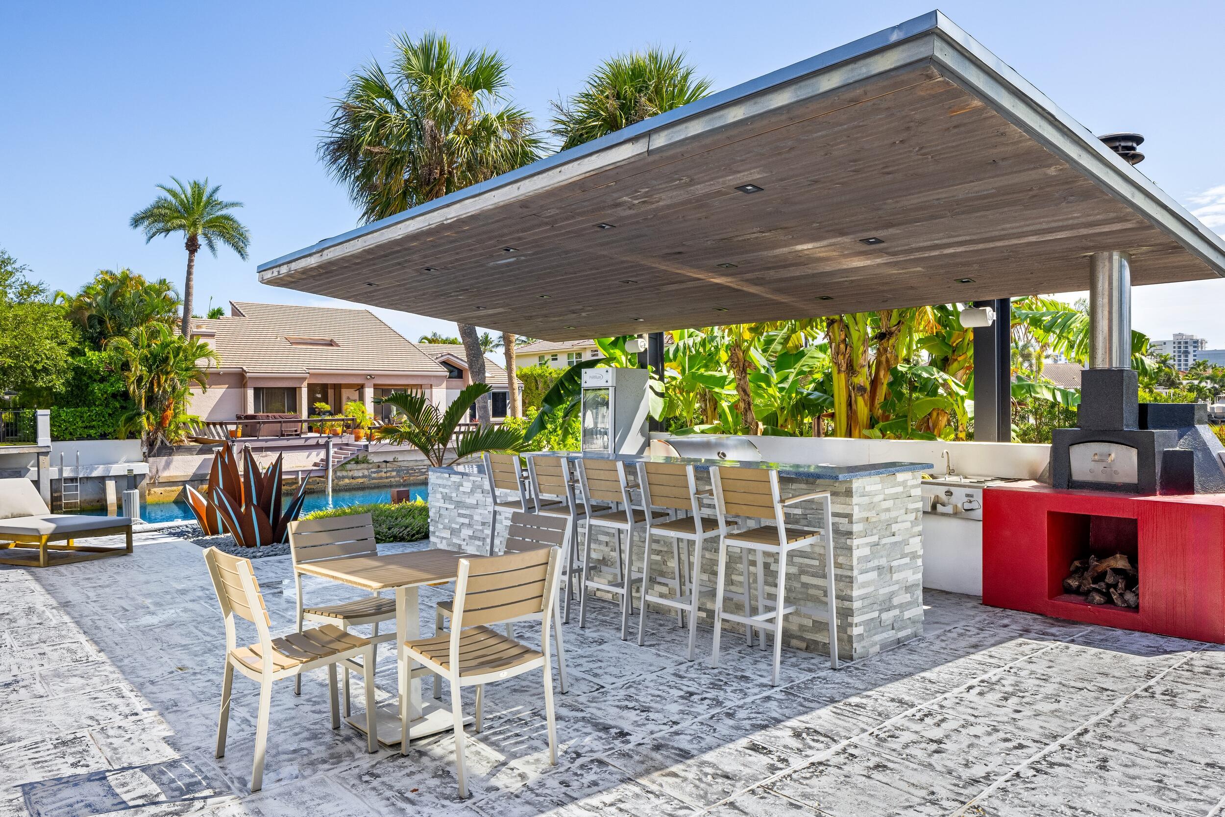 839 Northeast Bay Isle Drive Boca Raton, FL 33487 - Photo 18 of 103 a view of a patio with a table chairs and a backyard