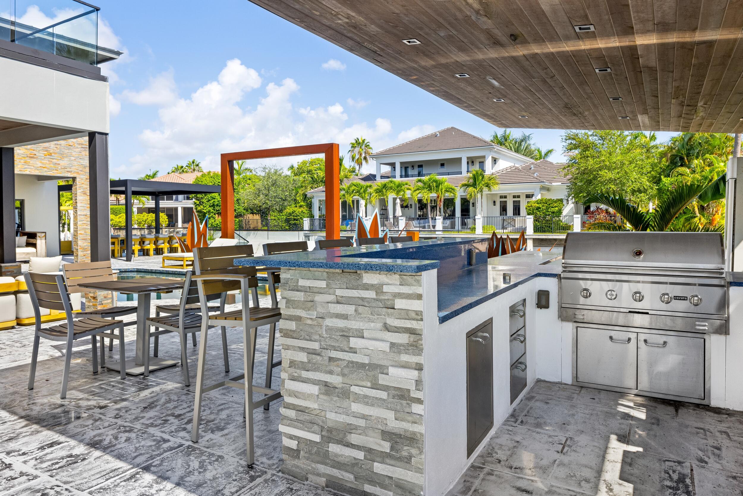 839 Northeast Bay Isle Drive Boca Raton, FL 33487 - Photo 19 of 103 a kitchen with stainless steel appliances kitchen island granite countertop a table and chairs in it