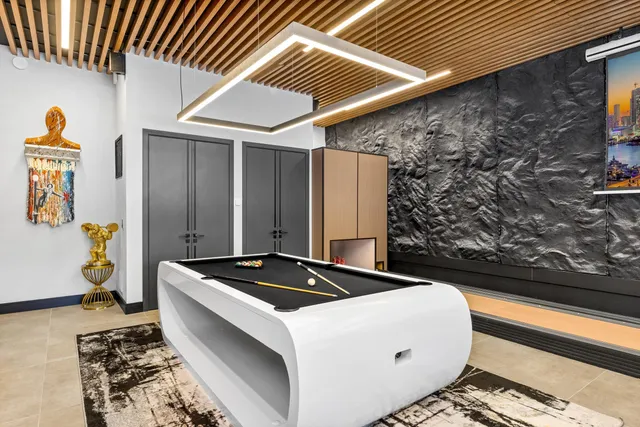 a spacious bedroom with a bed a couch and paintings on the wall