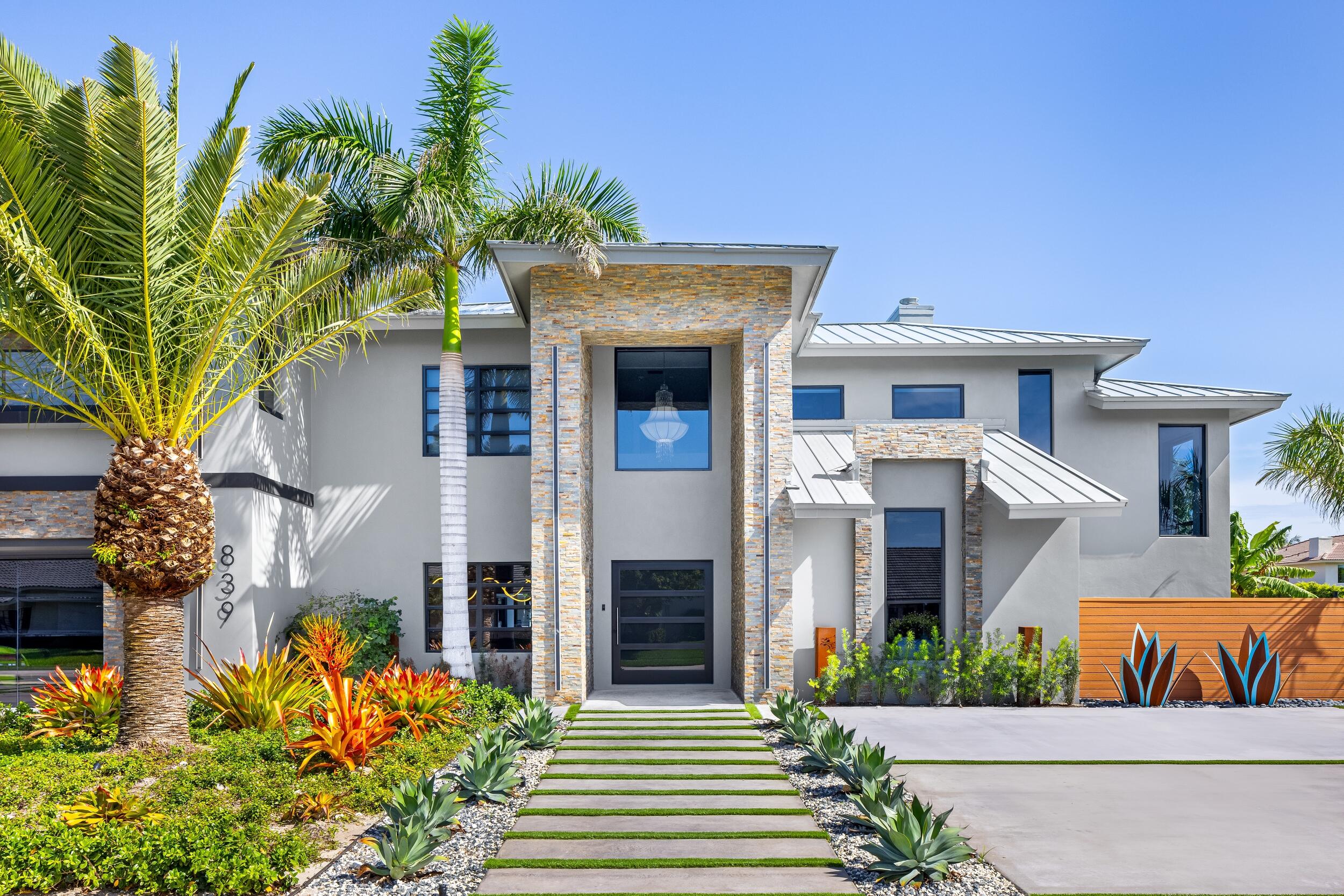 839 Northeast Bay Isle Drive Boca Raton, FL 33487 - Photo 4 of 103 a front view of a house with a garden
