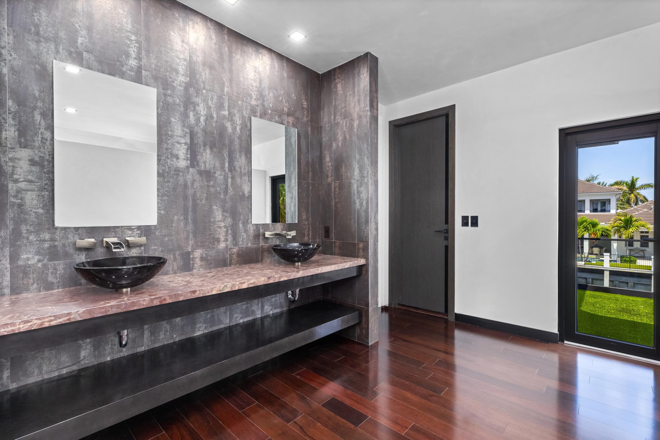 839 Northeast Bay Isle Drive Boca Raton, FL 33487 - Photo 57 of 103 a bathroom with double vanity sinks and a mirror