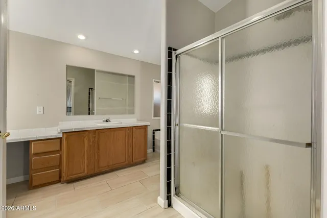 a bathroom with a double vanity sink a mirror and a shower