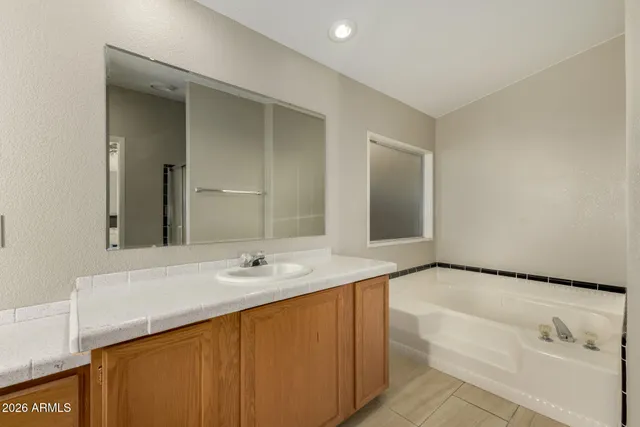 a bathroom with a bathtub sink and mirror