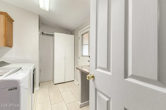 a view of a kitchen with white cabinets and entryway