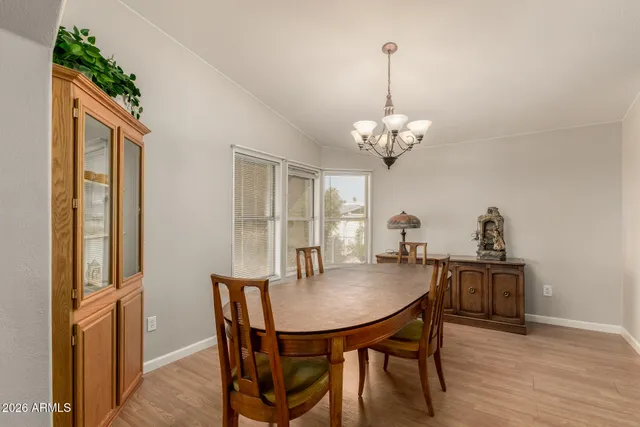 a dining room with furniture a chandelier and wooden floor