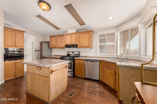 a kitchen with stainless steel appliances granite countertop a stove a sink and a refrigerator