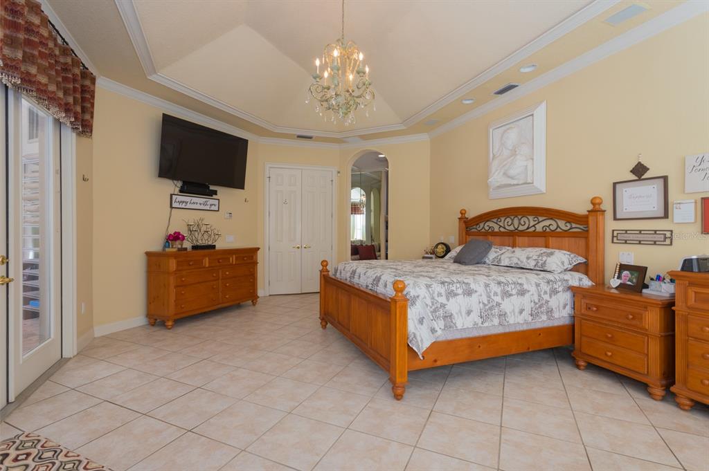 1640 Southeast 91st Place Ocala, FL 34480 - Photo 21 of 66 a bedroom with a bed and a flat tv screen on the dresser