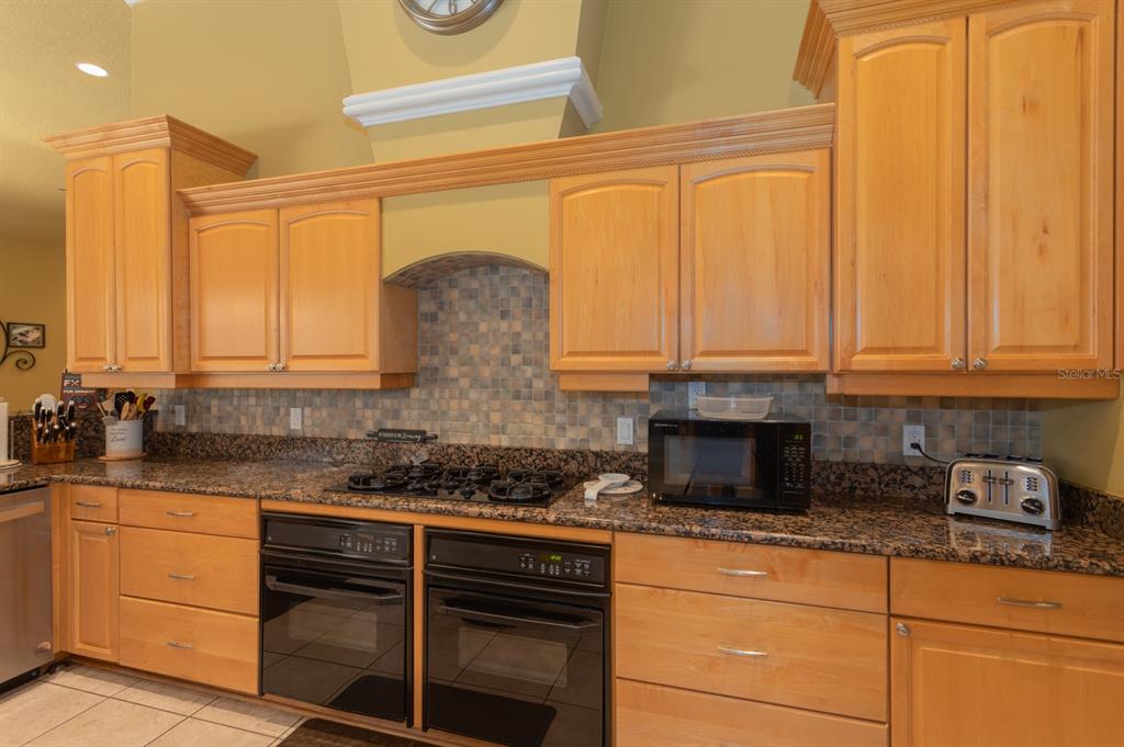 1640 Southeast 91st Place Ocala, FL 34480 - Photo 30 of 66 a kitchen with stainless steel appliances granite countertop a sink a stove and cabinets