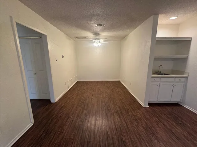 a view of a room with wooden floor and a sink
