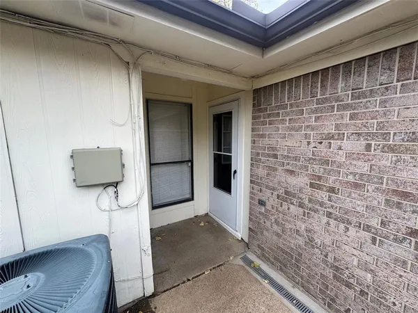 a hallway with a couch and a potted plant next to a window