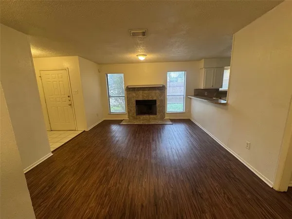 a view of a livingroom with wooden floor a fireplace and window